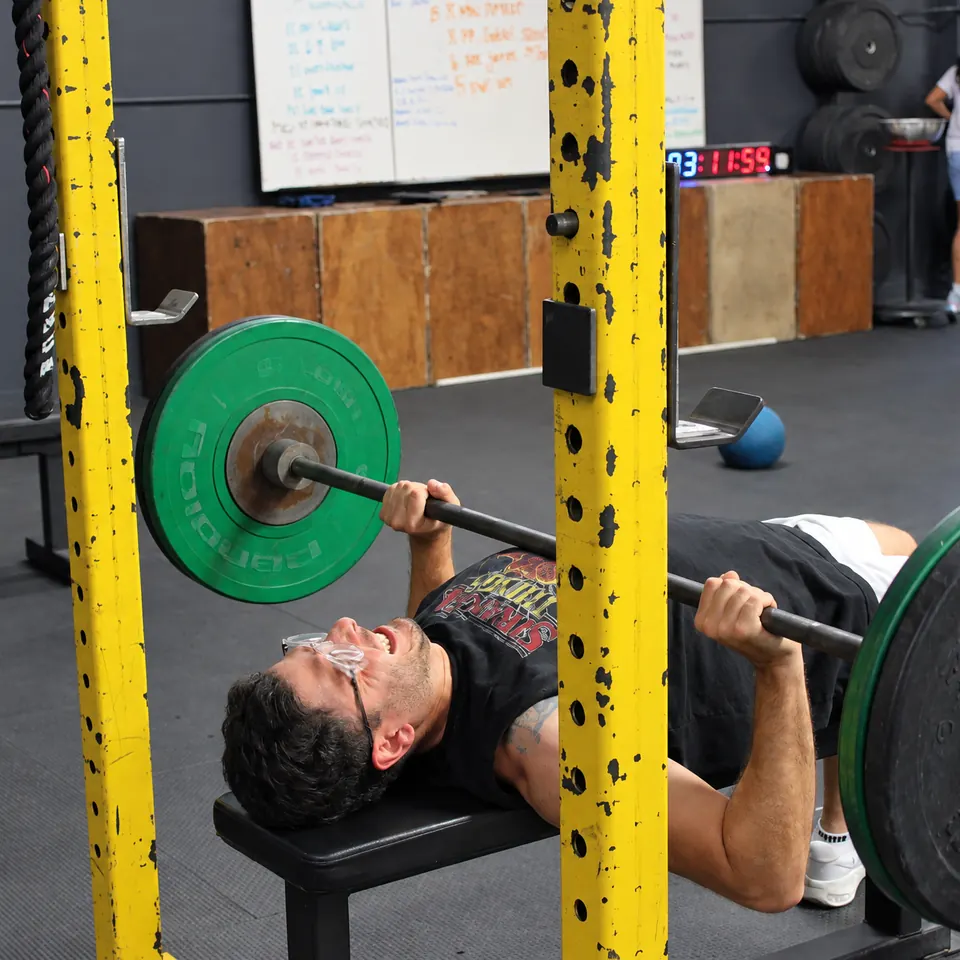 A member on the bench press, the bar over his chest