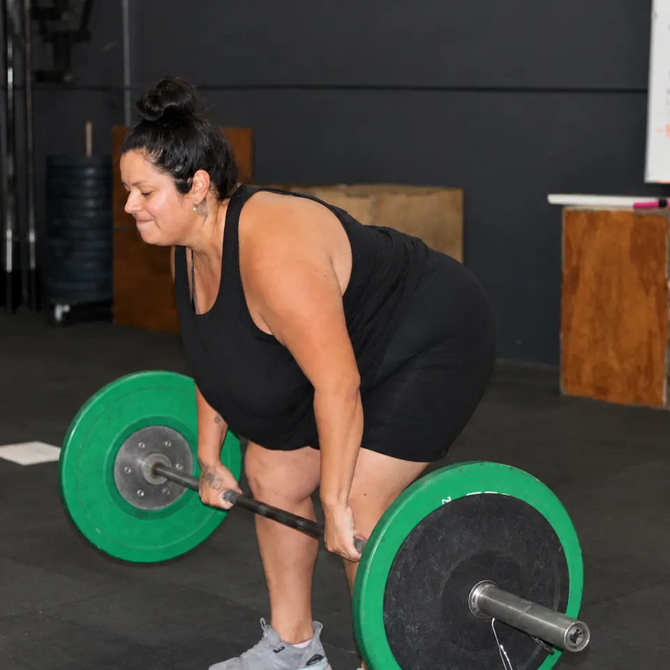 A member pulling a barbell off the floor